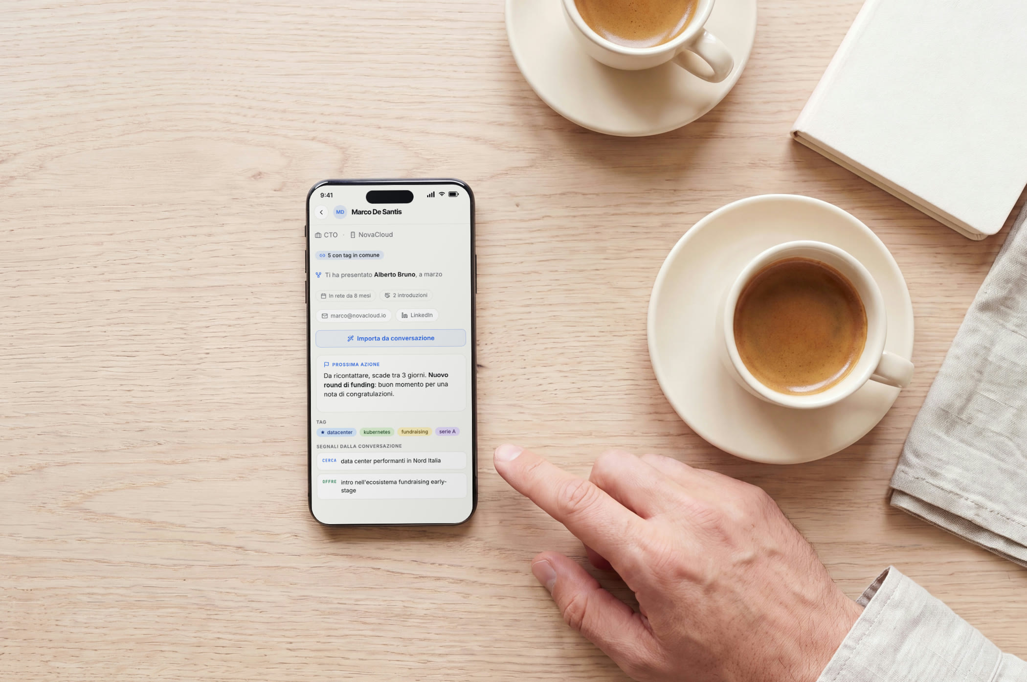 Un telefono sul tavolo di un caffè con la scheda di un contatto aperta, subito dopo un incontro